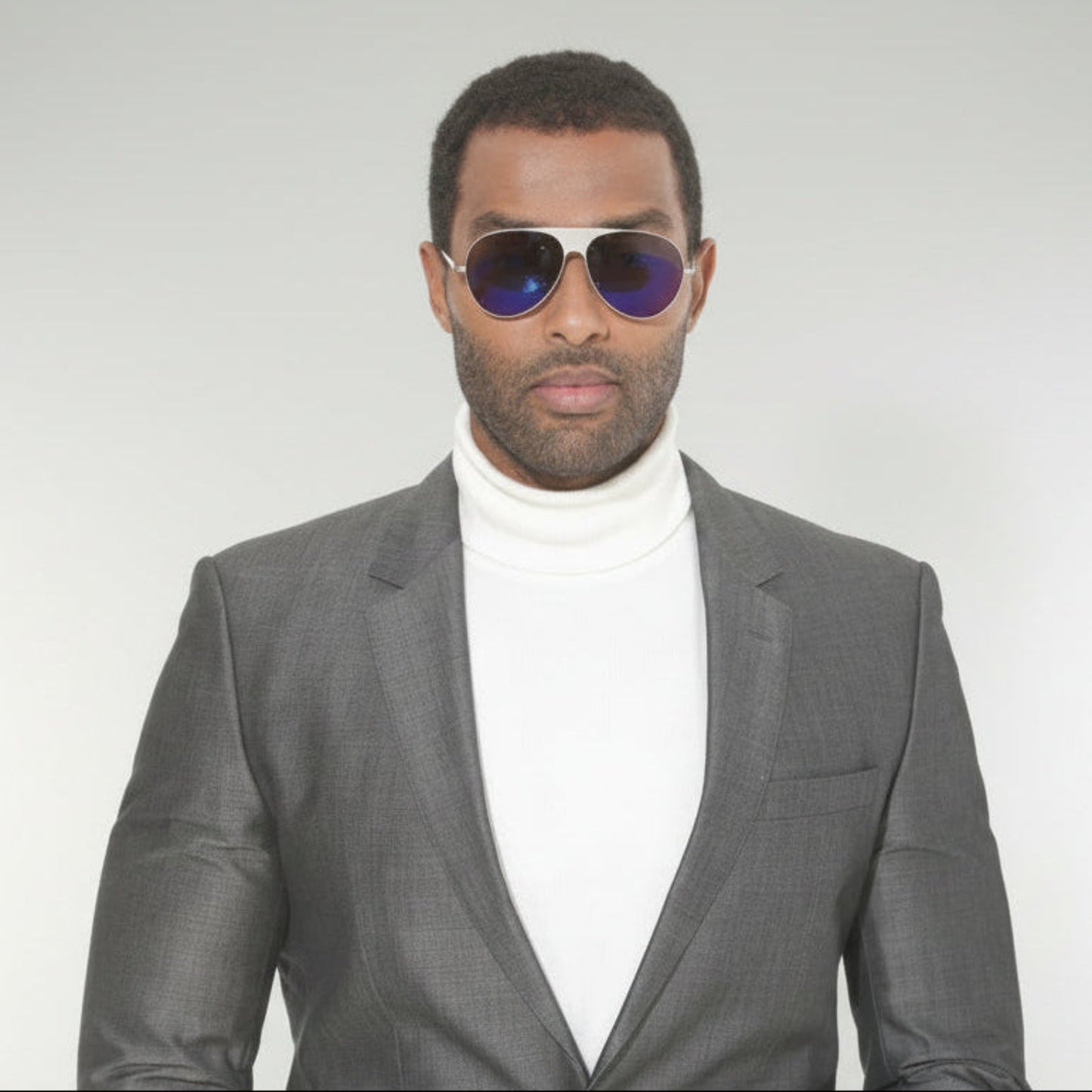 Man wearing a gray suit and PEARL sunglasses 